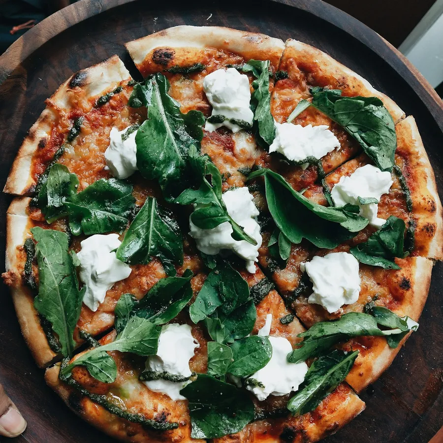 Pizza topped with arugula and ricotta